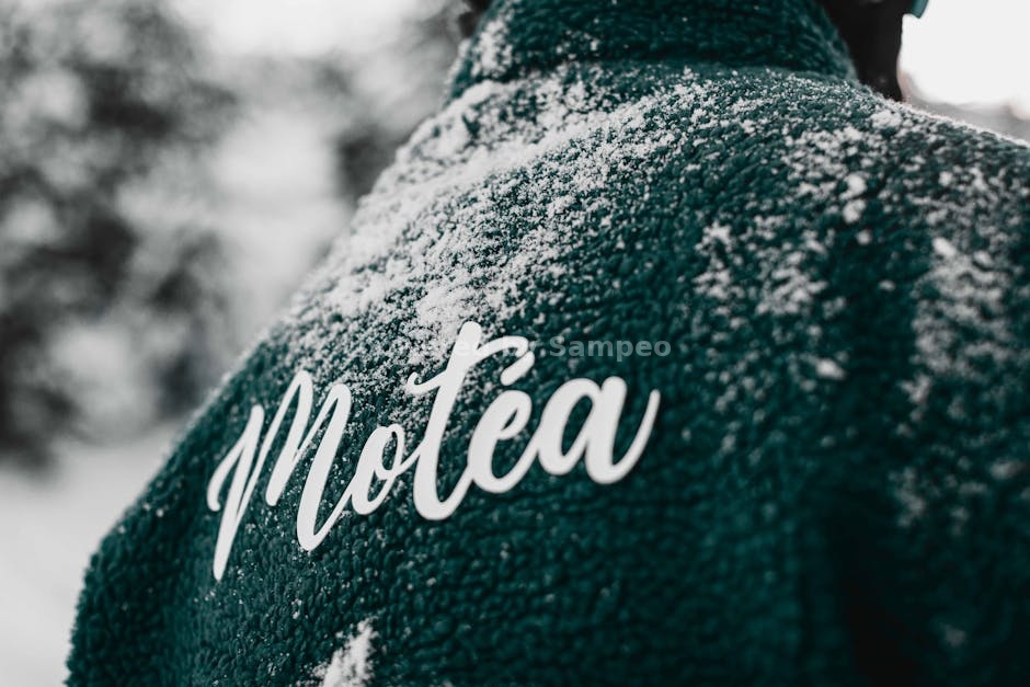 heated fleece technology - Close-up of a teal jacket with snow and Motéa branding in Brezovica, Serbia.