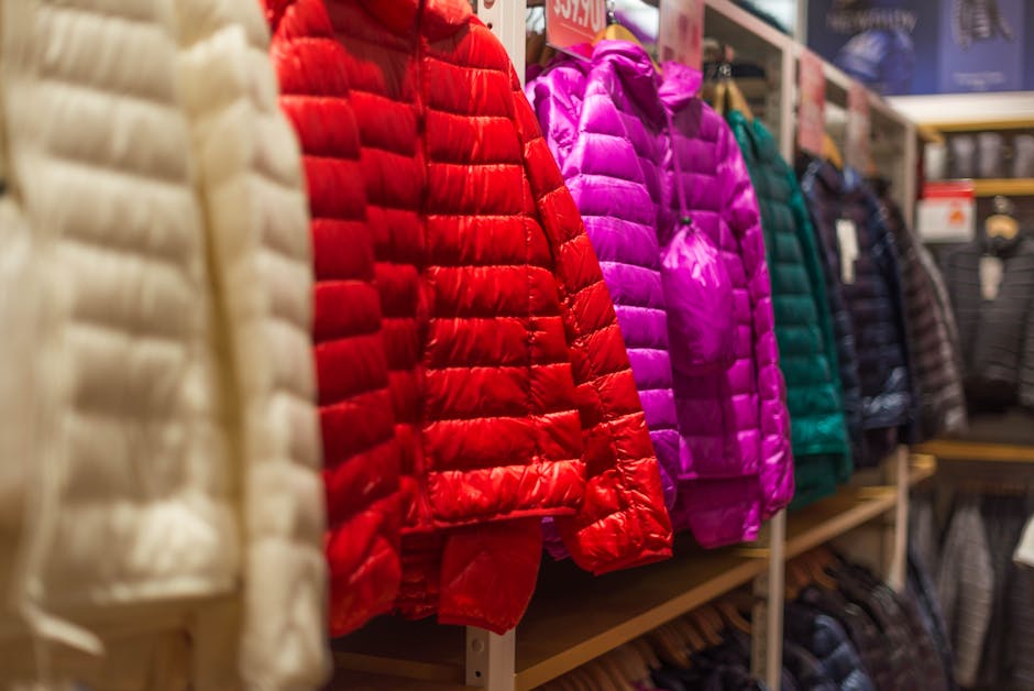 electric heated garments - Vibrant winter jackets on display in a clothing store, showcasing a variety of colors for shoppers.