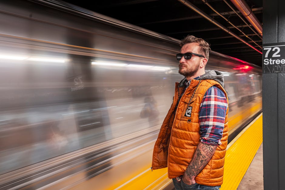 electric heated vest - Casual man standing at 72nd Street subway station, New York City, looking at a passing train.