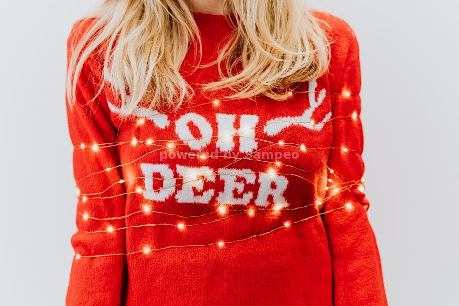 heated sweater - Close-up of a person wearing a red sweater wrapped in Christmas lights, emphasizing holiday cheer.
