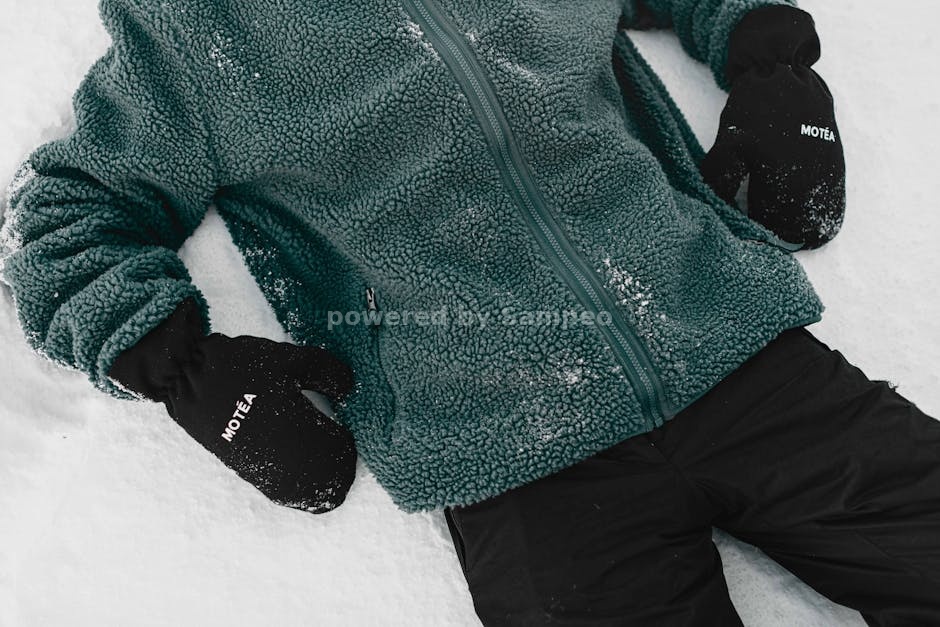 heated fleece outdoor activities - A person in a green fleece jacket and black gloves resting on snow in Brezovica, Serbia.