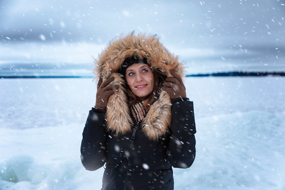 heated winter clothing outdoor activities - A woman in a fur-trimmed coat enjoying a snowy day outdoors in Ontario, Canada.